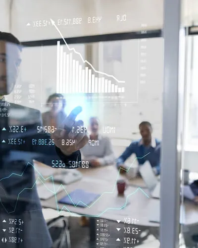 Data Analytics Ein Team diskutiert Daten auf einem großen Touchscreen in einem Büro